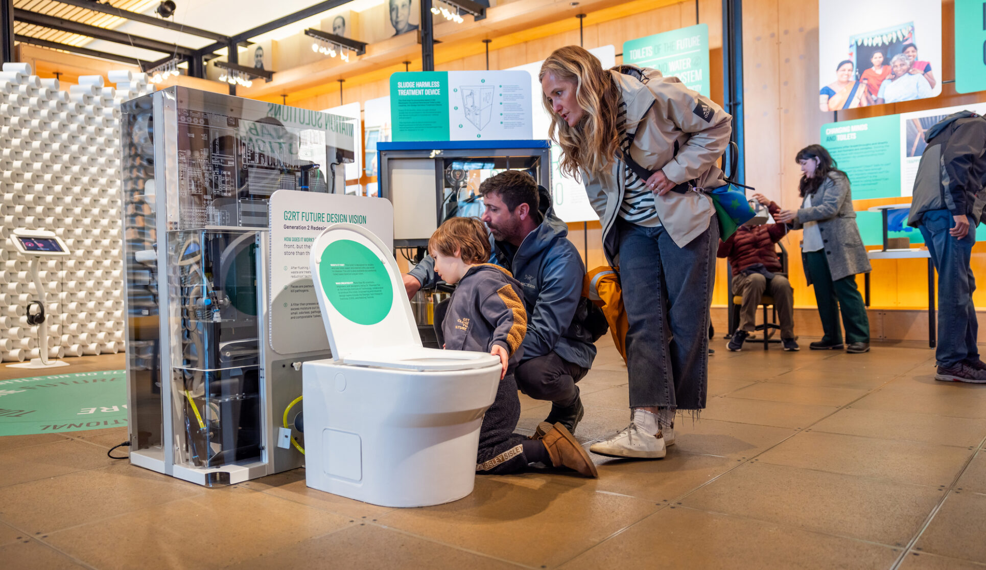 Family looking at a future toilet prototype at the Discovery Center.