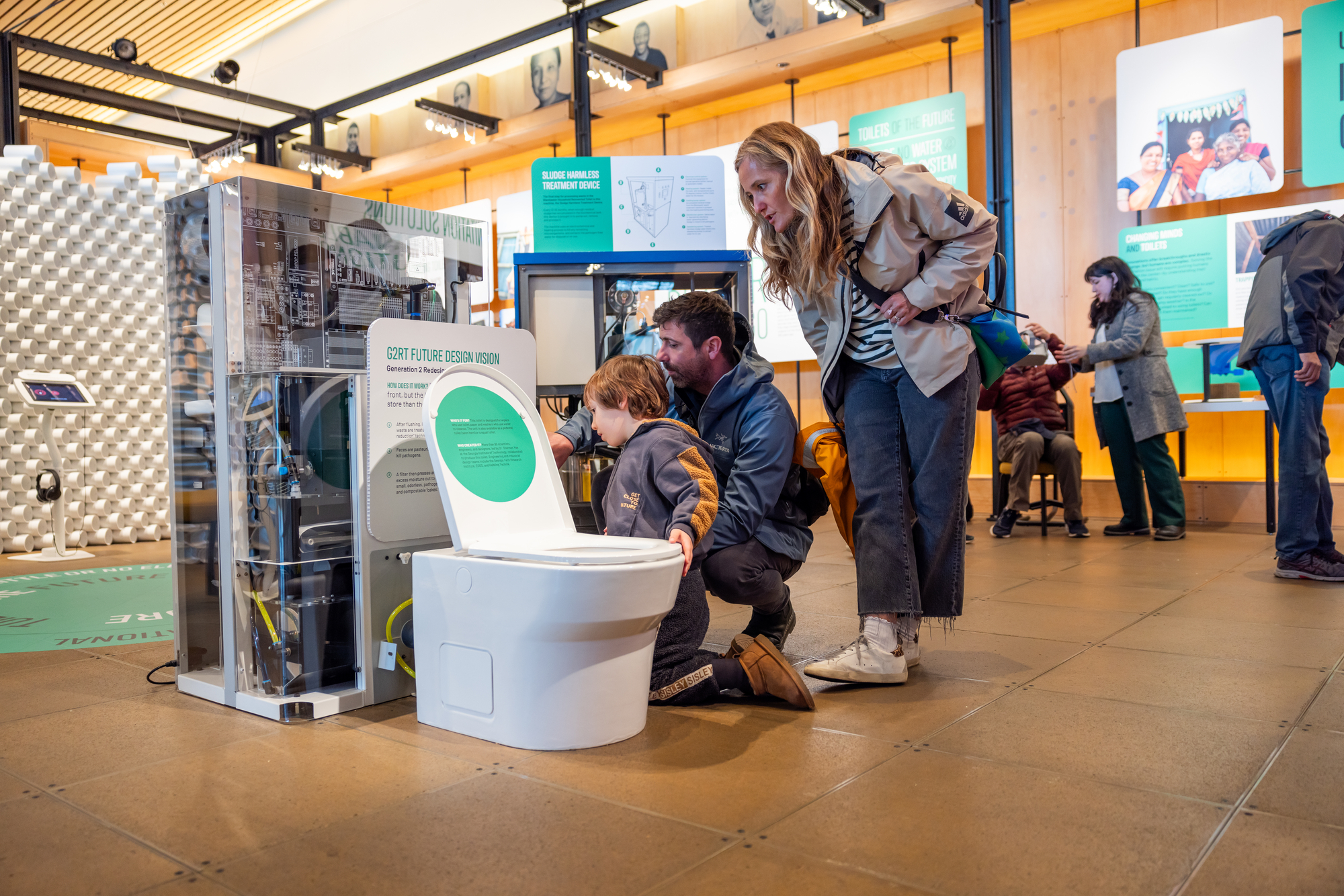 Family looking at a future toilet prototype at the Discovery Center.