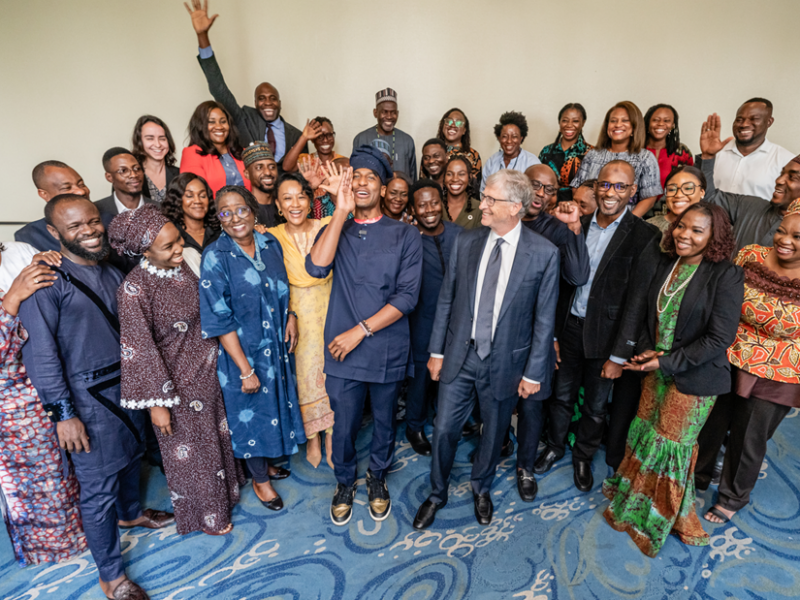 A group of attendees at the 2024 Goalkeepers conference poses smiling with Bill Gates and musician Jon Batiste.