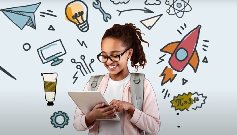 Young girl with glasses and a backpack looks at a tablet and smiles.