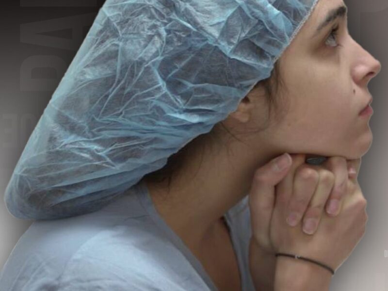 Female patient waits with surgical cap over her hair.